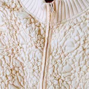 Elegant Cream Textured Sweater With Zipper Closure.